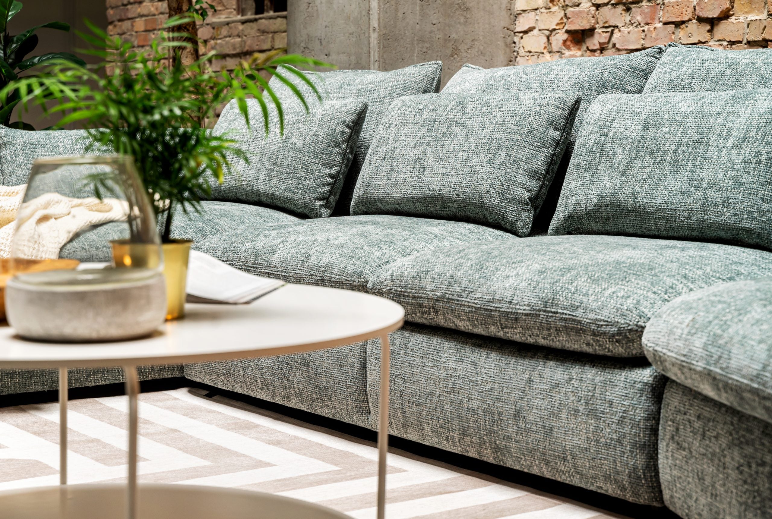 Óriási, zöld, sok párnás elemes kanapé.