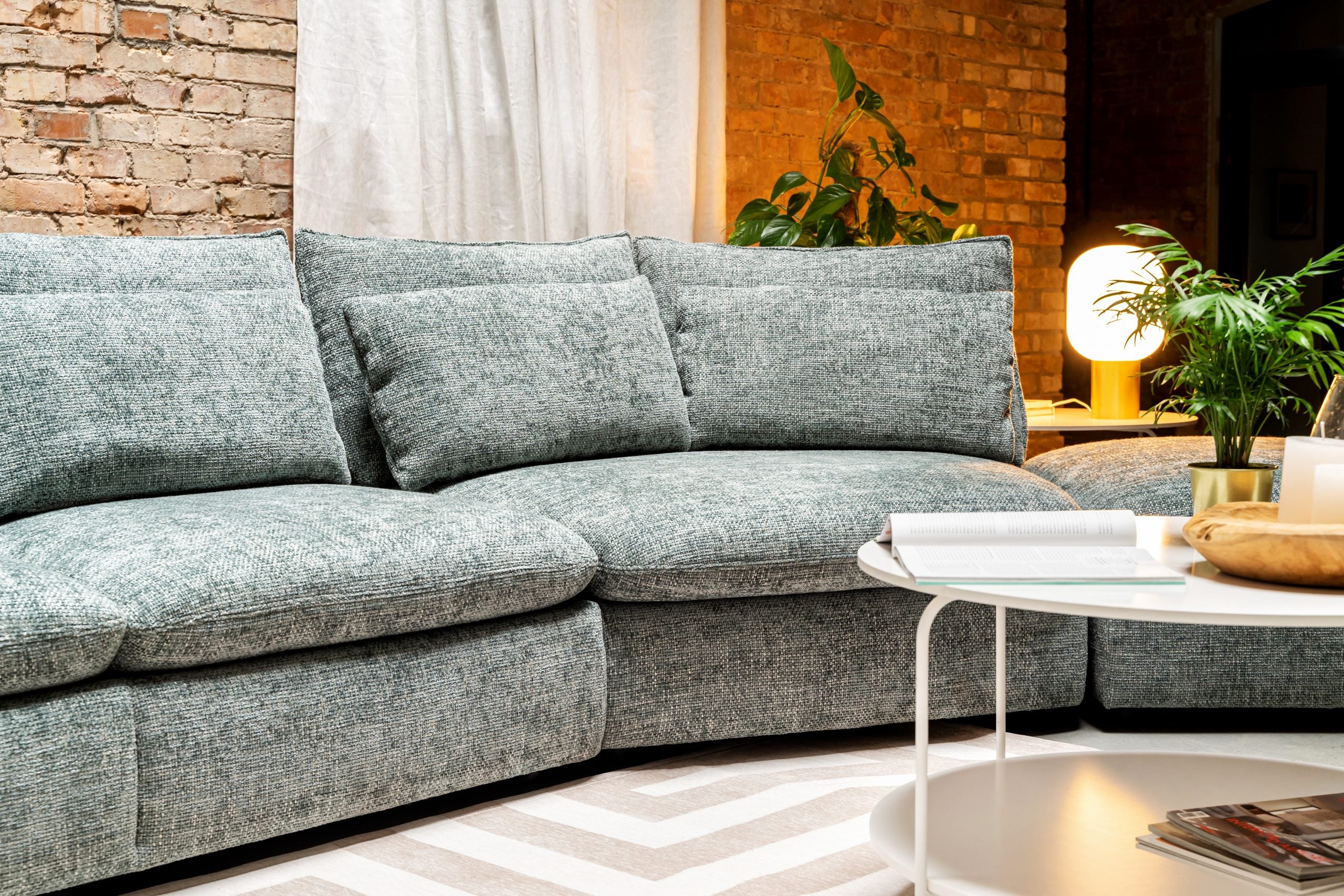 Óriási, zöld, sok párnás elemes kanapé.