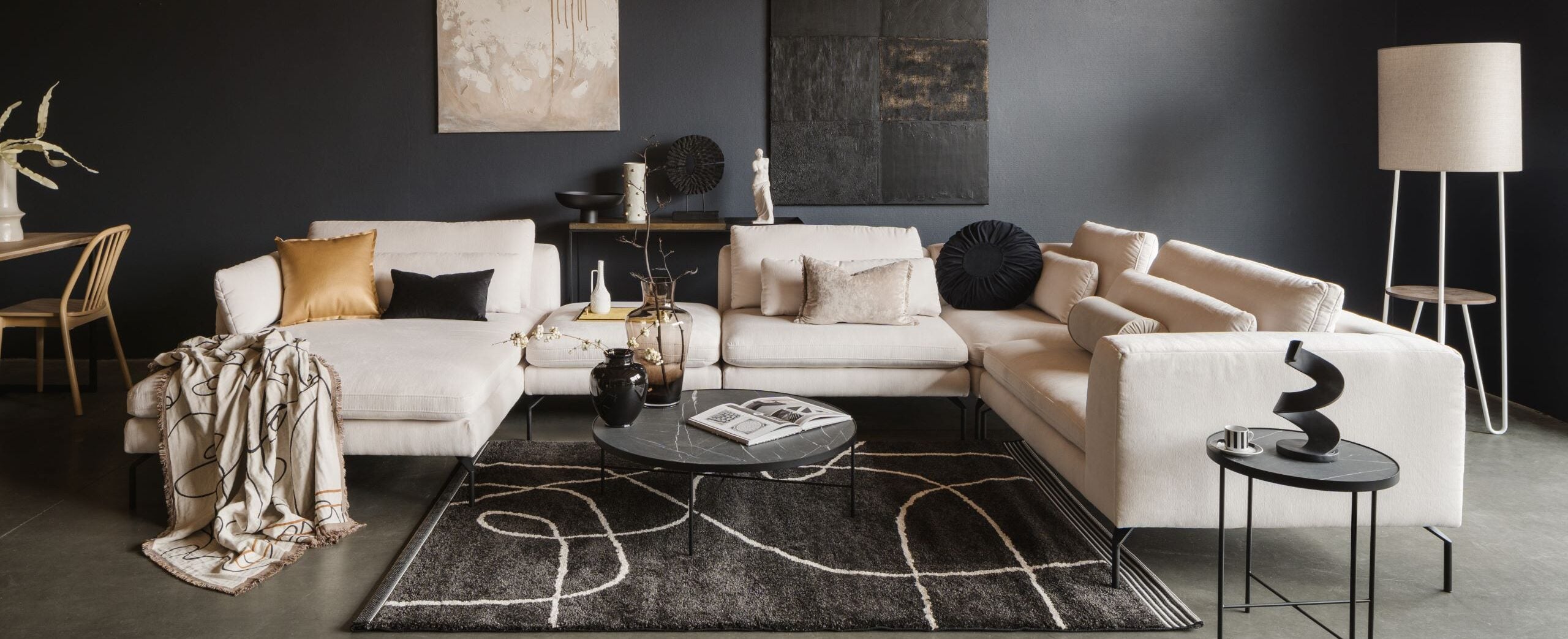 Puha, óriási kanapé, fehér párnával és vékony fekete lábbal.